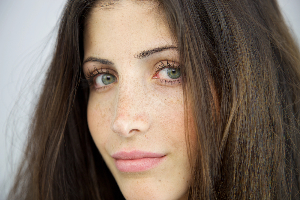 Twarz młodej kobiety po nałożeniu kremu do powiek